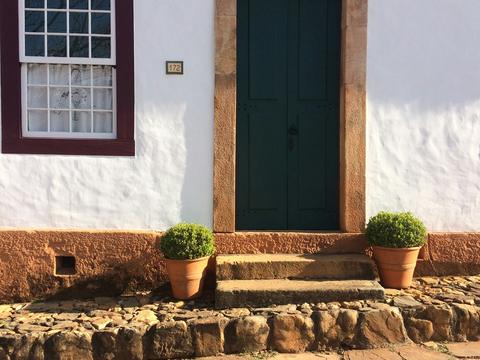 Fachada de casa colonial branca com porta verde em Tiradentes, Minas Gerais